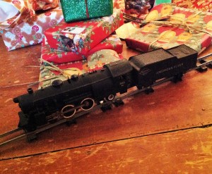 An antique train, presents, and a tree skirt adorn my tree